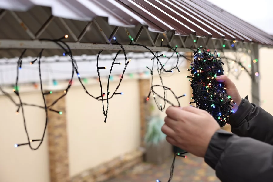 A man hanging Christmas lights